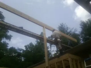 Carpenter setting a ridge beam over a new addition frame — Ice Dam Removal by Roofing Brothers in Old Bridge