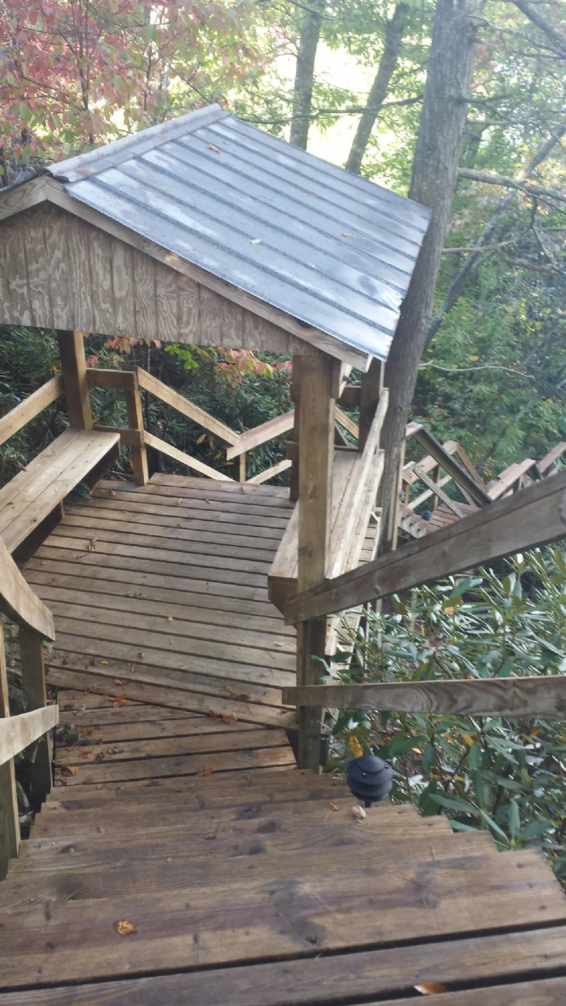 Metal roofed shelter over wooden steps on a wooded walkway — Skylight Repair & Installation work by our crew in Old Bridge