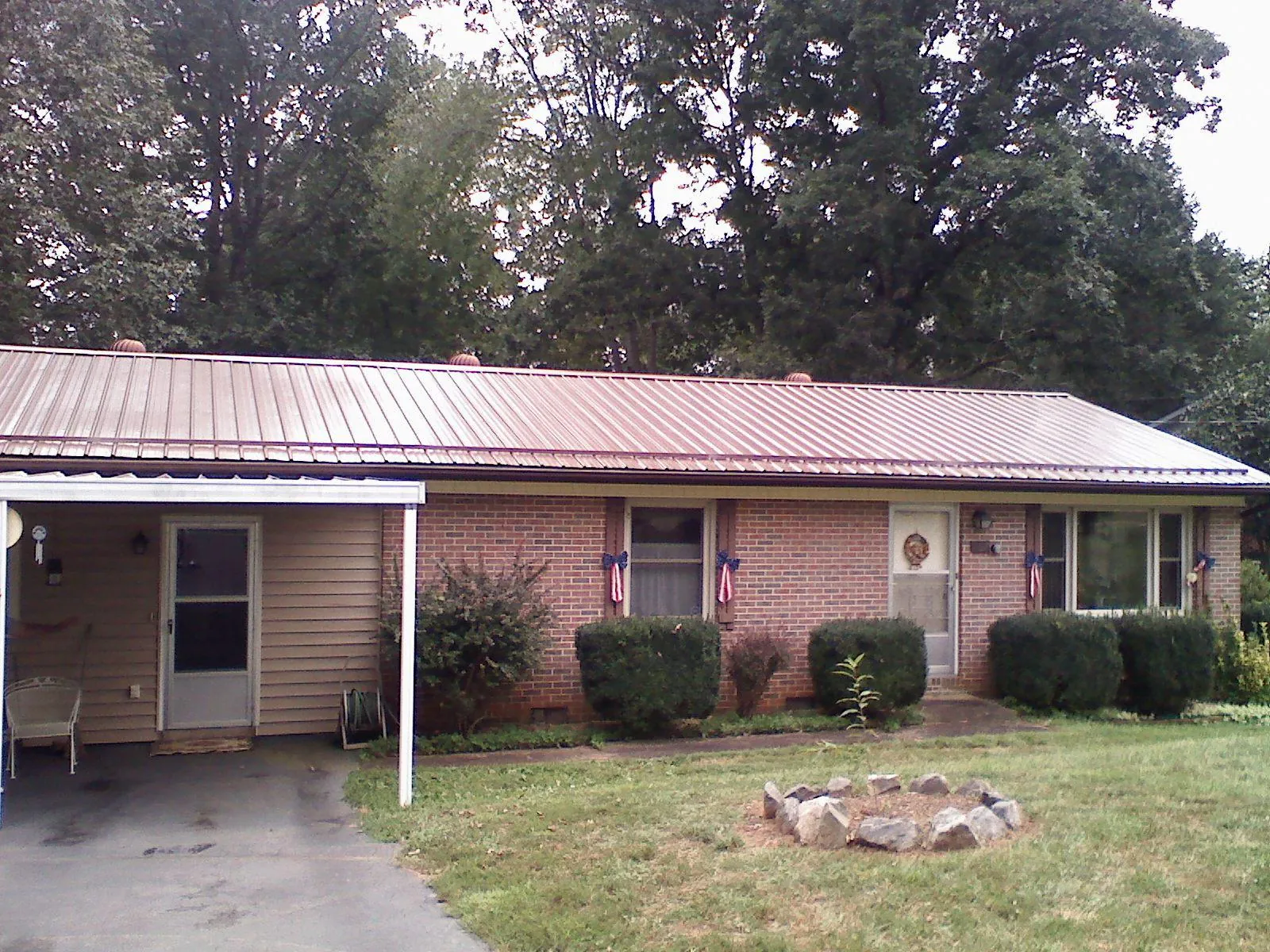 Bronze metal roof and carport on a brick ranch home — Roof Repair work by our crew in Old Bridge